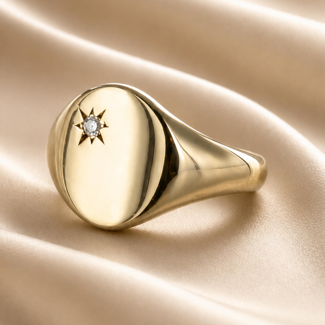Star Jewellers Oval Diamond Signet Ring with star-set diamond on cream satin