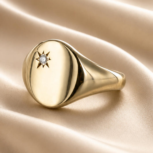 Star Jewellers Oval Diamond Signet Ring with star-set diamond on cream satin