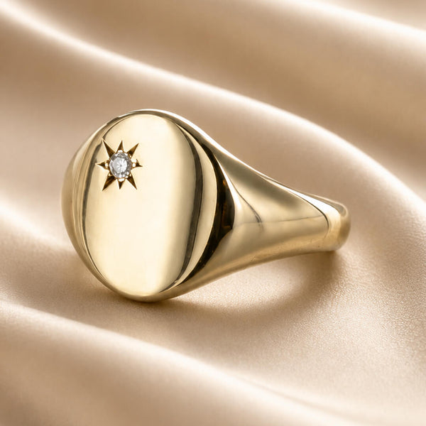 Star Jewellers Oval Diamond Signet Ring with star-set diamond on cream satin