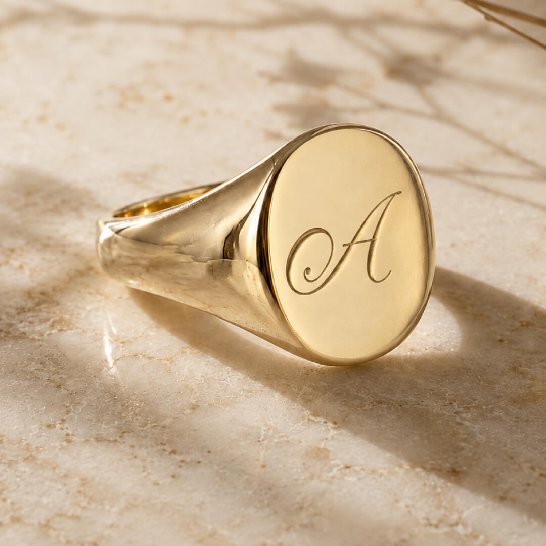 Star Jewellers Oval Shape Signet Ring with a plain polished gold face on textured stone
