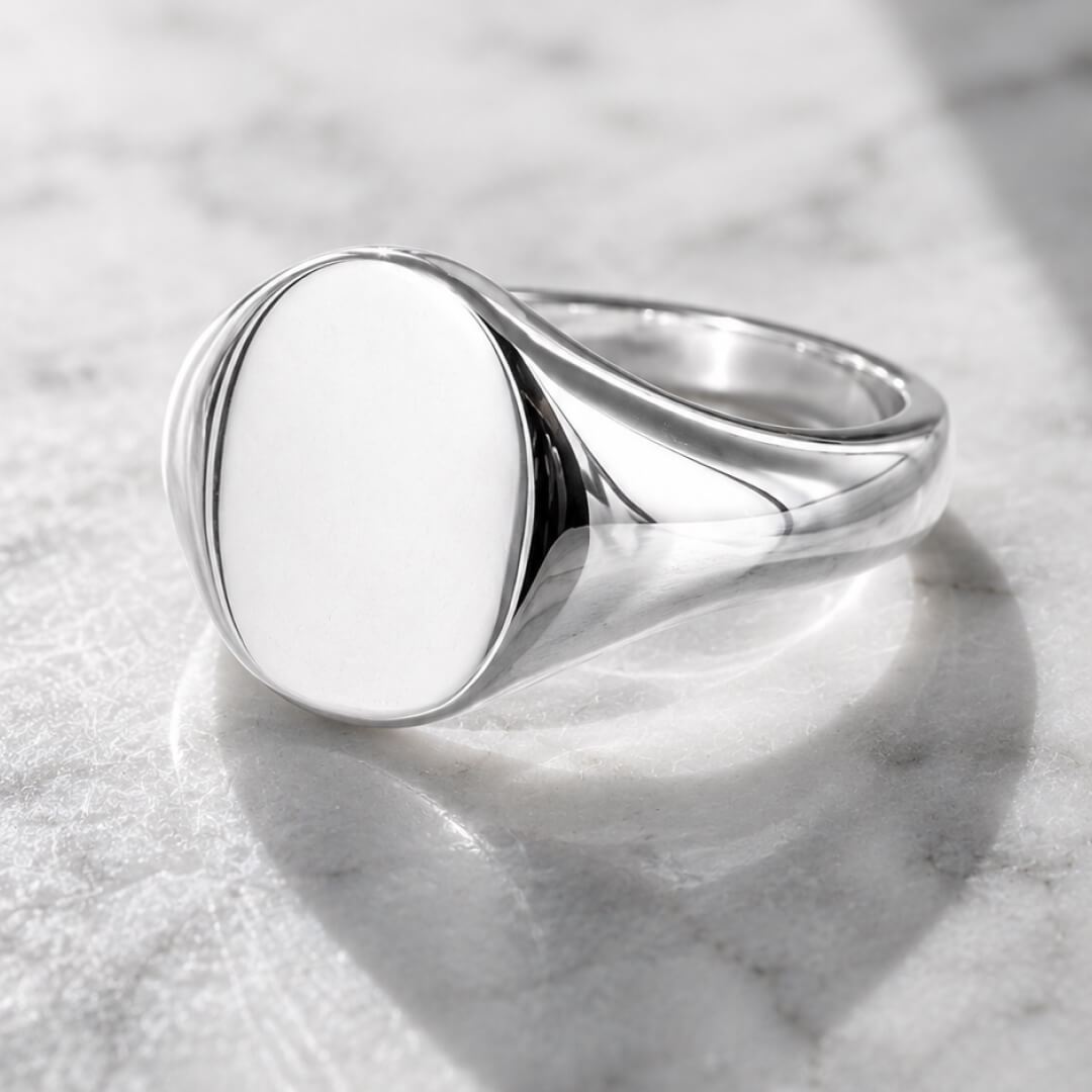 Star Jewellers Oval Shape Silver Signet Ring with a plain polished face on marble