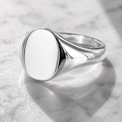Star Jewellers Oval Shape Silver Signet Ring with a plain polished face on marble