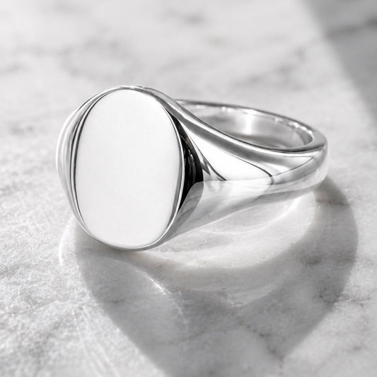 Star Jewellers Oval Shape Silver Signet Ring with a plain polished face on marble