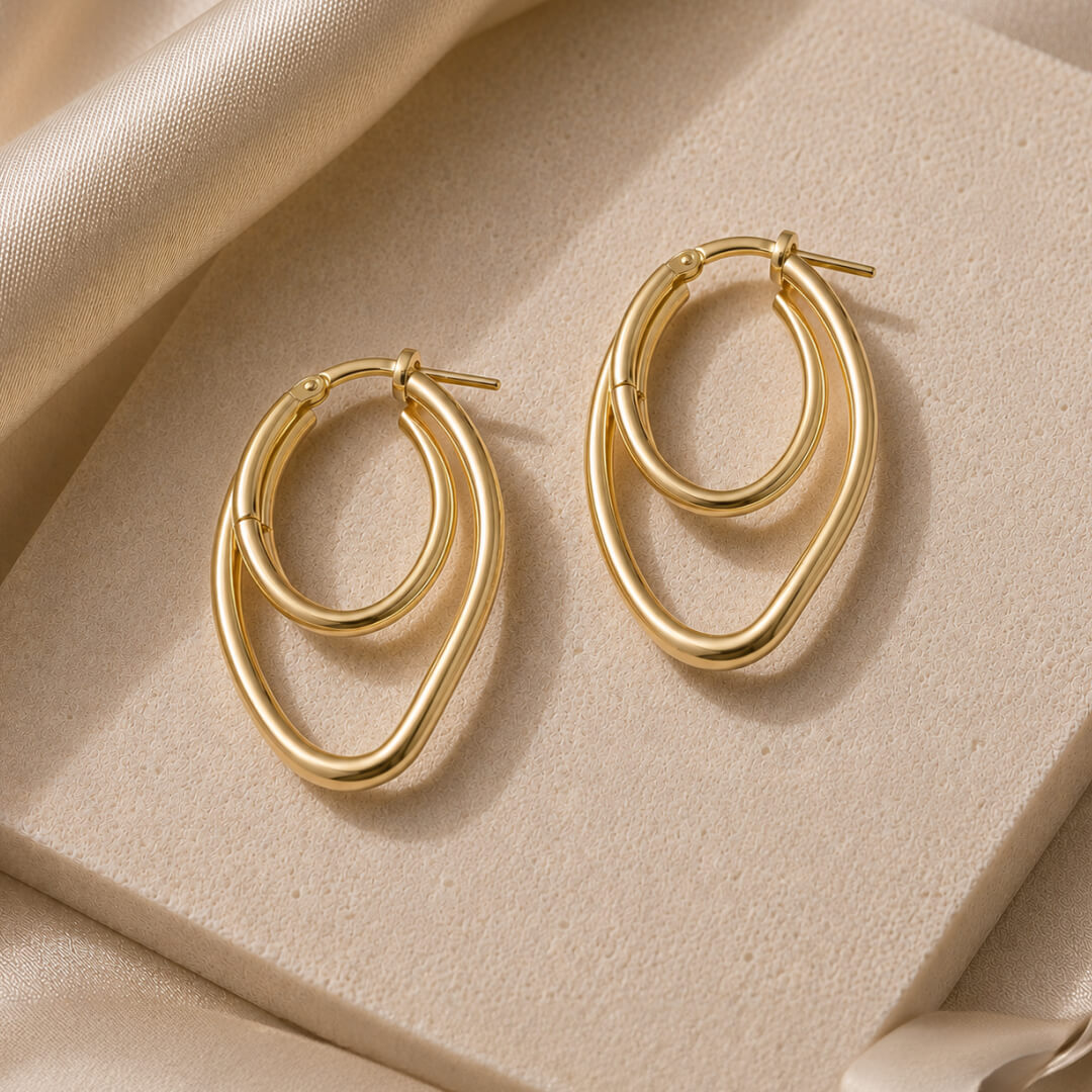 Star Jewellers Twisted Paper Clips Gold Plated Earrings displayed on a textured stone surface
