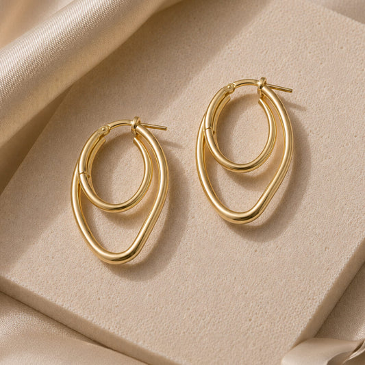 Star Jewellers Twisted Paper Clips Gold Plated Earrings displayed on a textured stone surface